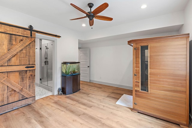 empty room with ceiling fan, recessed lighting, baseboards, wood finished floors, and a sauna
