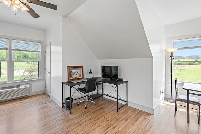 office with a wall mounted air conditioner, light wood-style flooring, a ceiling fan, baseboards, and vaulted ceiling
