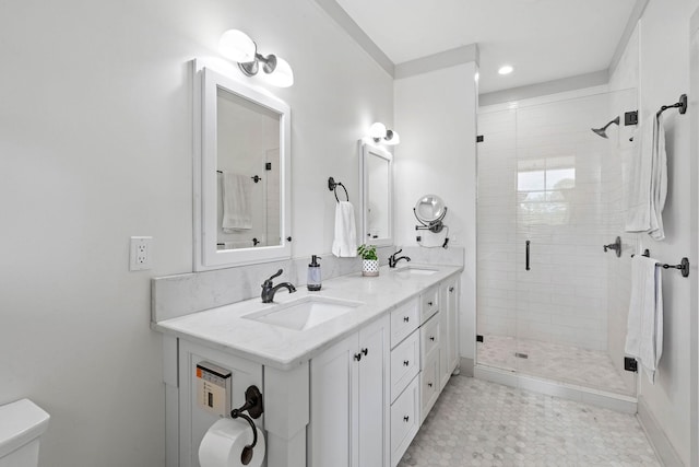 full bathroom featuring a sink, a shower stall, toilet, and double vanity