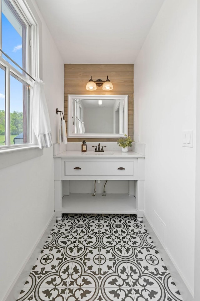 bathroom with baseboards, a sink, and a healthy amount of sunlight