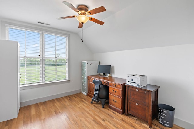 home office featuring a ceiling fan, visible vents, baseboards, lofted ceiling, and light wood-style flooring