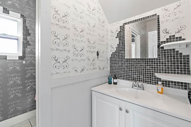 bathroom with vanity, tile patterned floors, a wainscoted wall, and wallpapered walls
