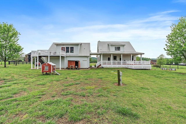 rear view of property featuring stairs, a yard, a porch, and metal roof