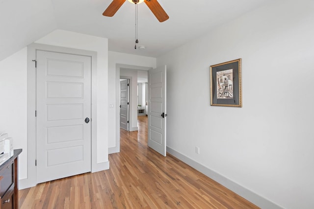 unfurnished bedroom featuring a ceiling fan, baseboards, and light wood-type flooring