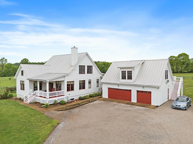 view of front of house with a porch, a chimney, metal roof, and a front lawn