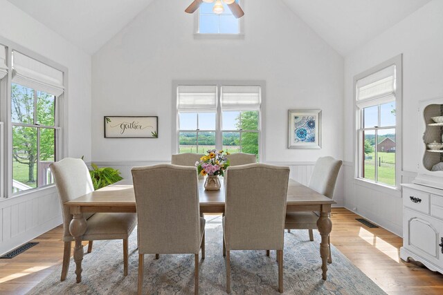 dining area with visible vents, a healthy amount of sunlight, and a wainscoted wall