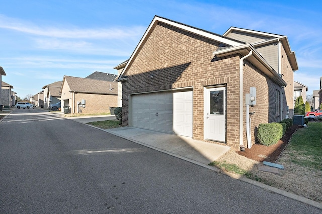 131 Benjamin Ln, Hendersonville, TN 37075 - view of side of home with a residential view, central air condition unit, driveway, brick siding, and a garage