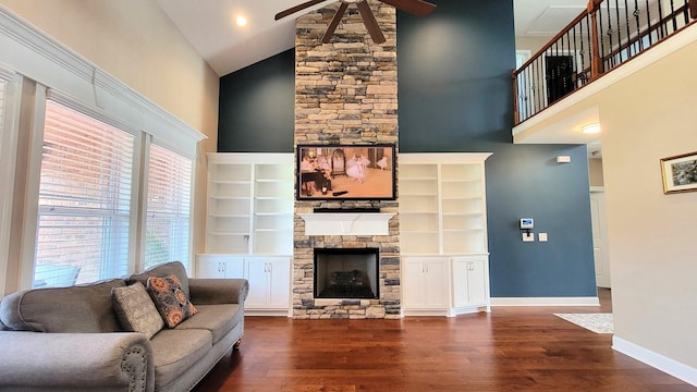 living area featuring ceiling fan, baseboards, a fireplace, high vaulted ceiling, and dark wood-style flooring