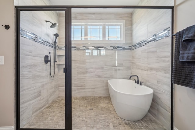 full bathroom with a shower stall and a freestanding bath