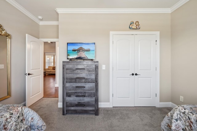 bedroom featuring a closet, baseboards, crown molding, and carpet
