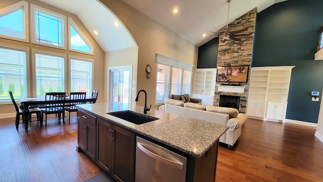 kitchen with a sink, dark wood finished floors, ceiling fan, and high vaulted ceiling