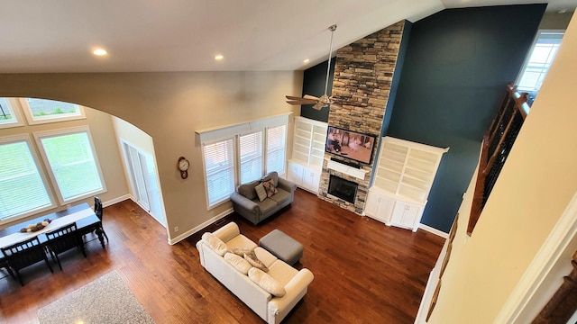 living area with ceiling fan, arched walkways, vaulted ceiling, and dark wood-type flooring