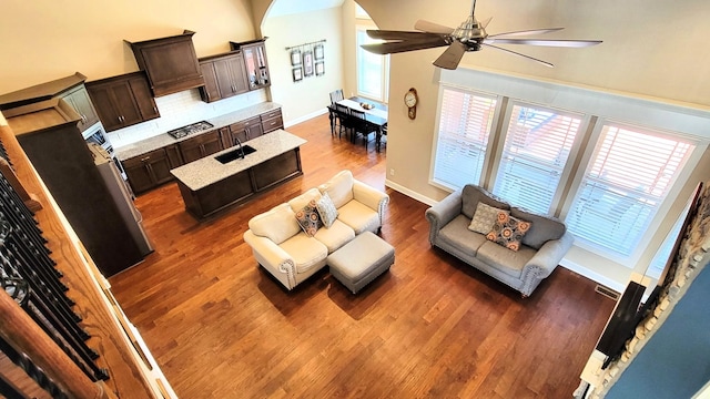 living room featuring dark wood finished floors, a wealth of natural light, a ceiling fan, and visible vents