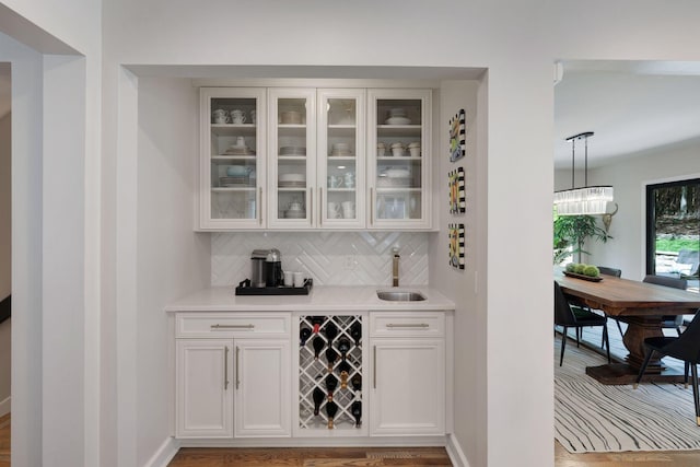 516 Harpeth Trace Dr, Nashville, TN 37221 - bar featuring decorative light fixtures, baseboards, a sink, indoor wet bar, and backsplash