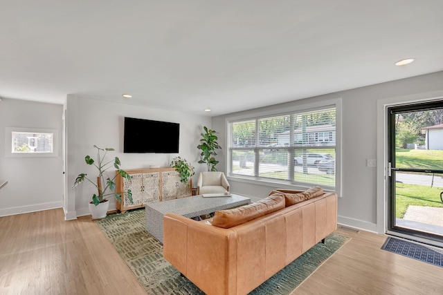living area with recessed lighting, baseboards, and light wood-style flooring