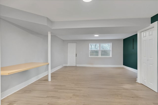 below grade area featuring light wood-style flooring and baseboards