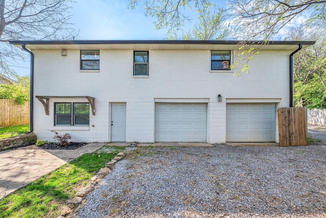 view of front of house with a garage, driveway, and fence