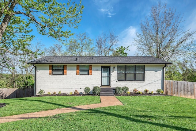 ranch-style house featuring brick siding, a front yard, and fence