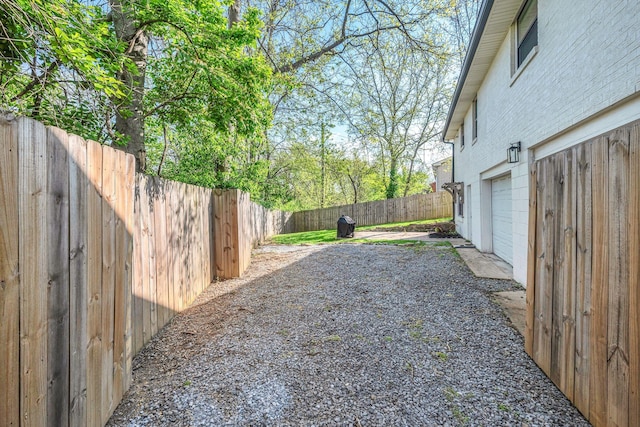 view of yard with a fenced backyard and a garage