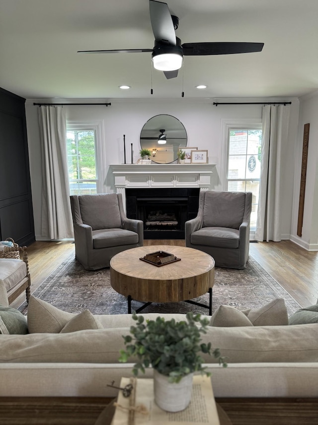 living room featuring a fireplace, light wood finished floors, ceiling fan, and recessed lighting