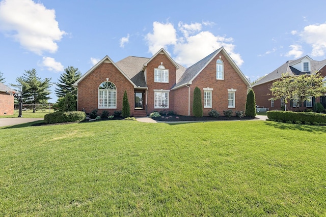 traditional-style house featuring brick siding and a front yard