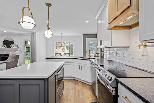kitchen with a sink, light wood-style floors, gray cabinetry, stainless steel appliances, and recessed lighting
