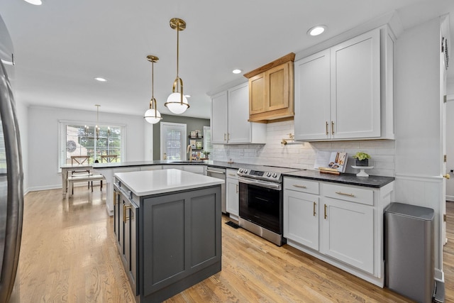 kitchen with tasteful backsplash, stainless steel appliances, light wood-style flooring, and a sink