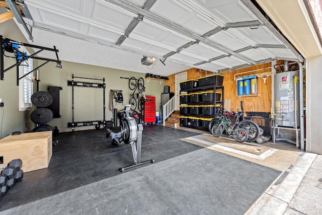 exercise room with gas water heater and a garage
