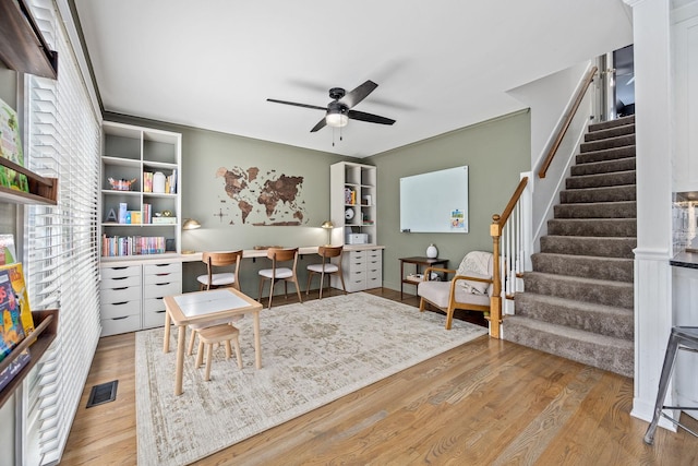 interior space featuring a ceiling fan, visible vents, and wood finished floors