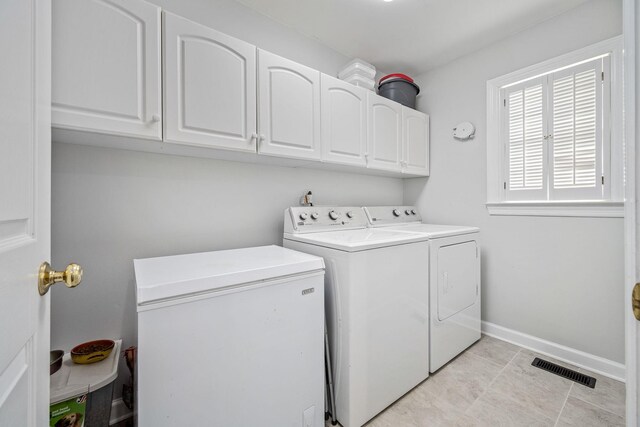 laundry area featuring baseboards, visible vents, cabinet space, and independent washer and dryer