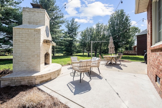 view of patio with outdoor dining space and an outdoor brick fireplace