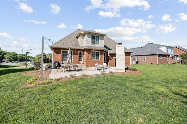 rear view of house with brick siding, a yard, and a patio area