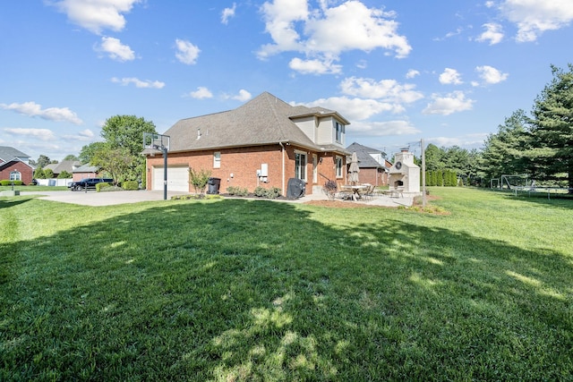 view of side of property featuring brick siding, driveway, a yard, and an attached garage