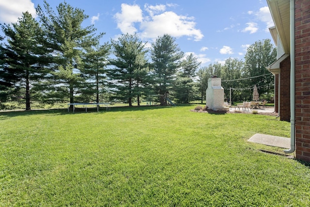 view of yard with a patio, a trampoline, and a playground