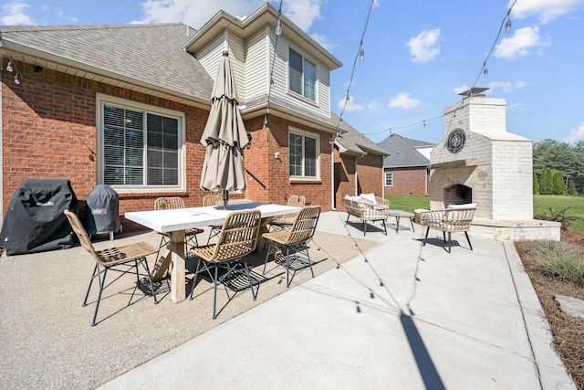 view of patio with outdoor dining area, exterior fireplace, and grilling area