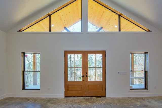 foyer entrance featuring baseboards, a wealth of natural light, high vaulted ceiling, and french doors