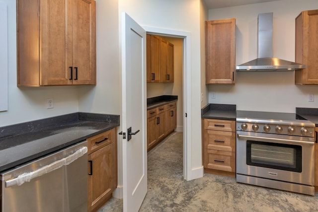 kitchen featuring stainless steel appliances, dark stone countertops, brown cabinets, and wall chimney range hood