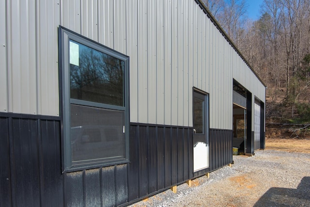 view of property exterior with board and batten siding and an outbuilding