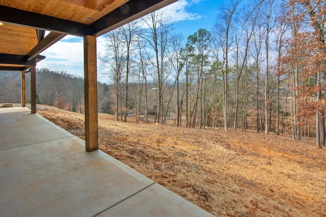 view of yard featuring a view of trees and a patio area