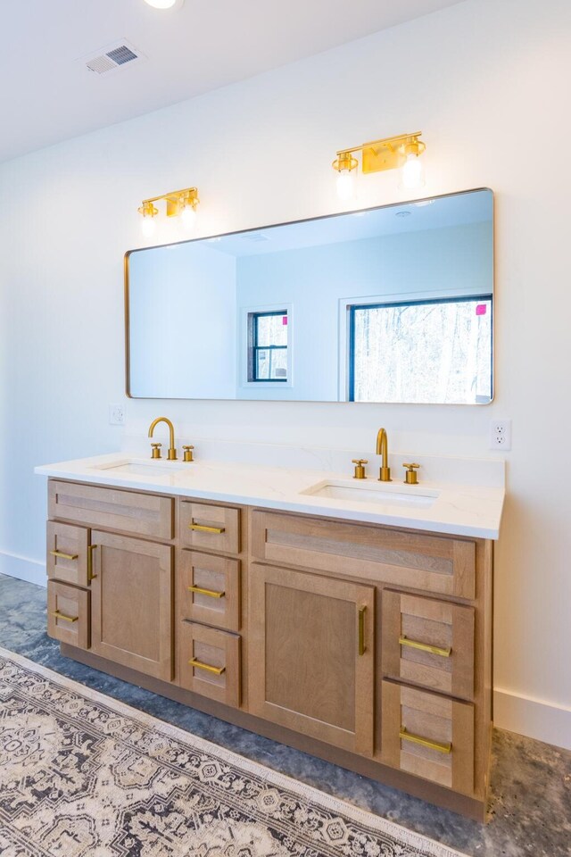 bathroom with double vanity, visible vents, baseboards, and a sink
