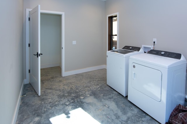 laundry area with baseboards and washer and dryer