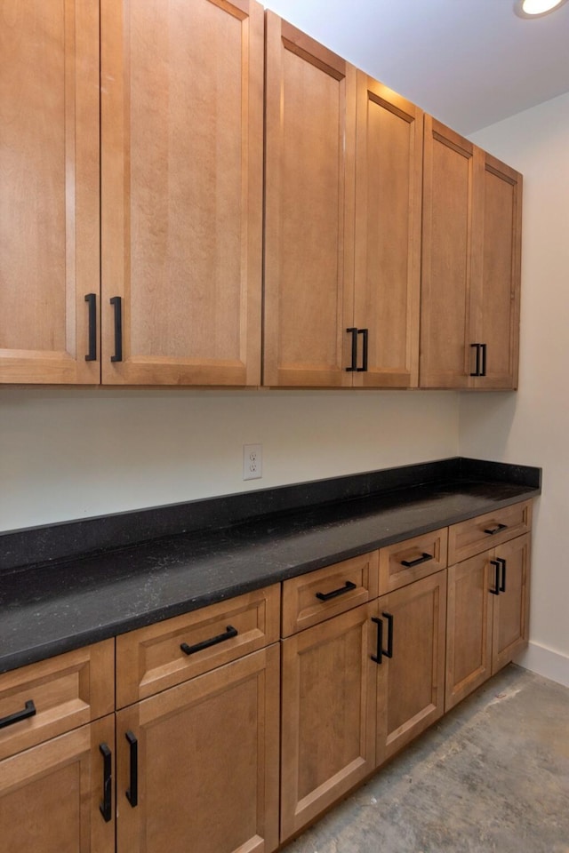 kitchen with unfinished concrete floors and baseboards
