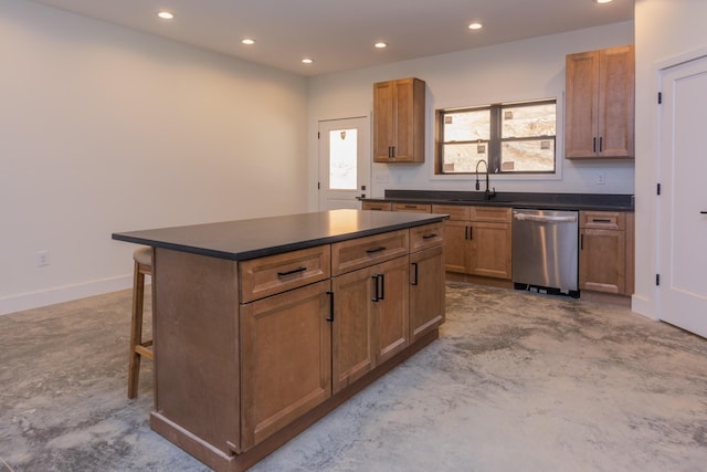 kitchen with concrete floors, dark countertops, a sink, dishwasher, and recessed lighting