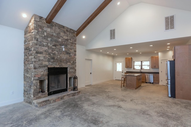 living area with beamed ceiling, a stone fireplace, visible vents, and high vaulted ceiling