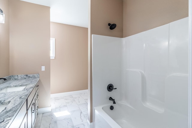 bathroom featuring baseboards, bathing tub / shower combination, marble finish floor, and vanity