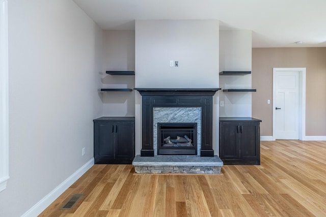 unfurnished living room with baseboards, wood finished floors, and visible vents