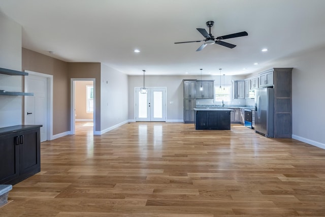 unfurnished living room with recessed lighting, light wood-style floors, a ceiling fan, and baseboards