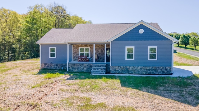 view of front of house with stone siding, a front lawn, and covered porch