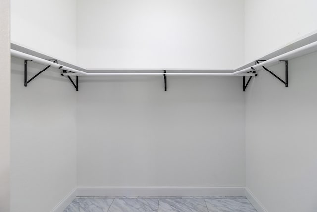 spacious closet featuring marble finish floor