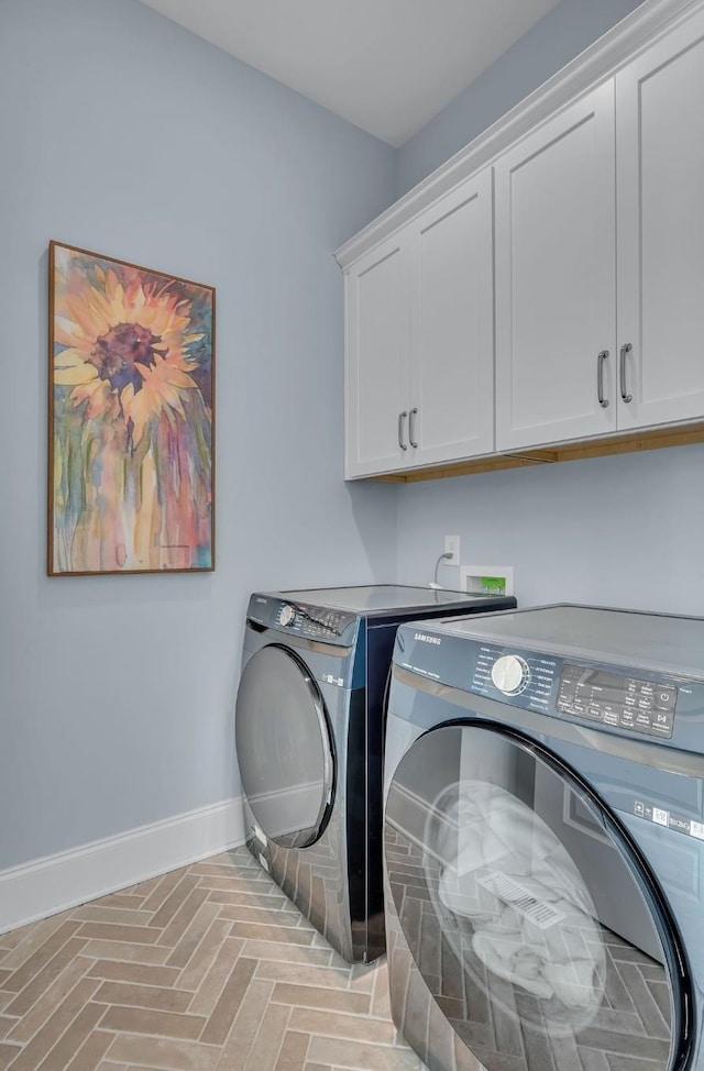 clothes washing area featuring cabinet space, brick floor, baseboards, and separate washer and dryer